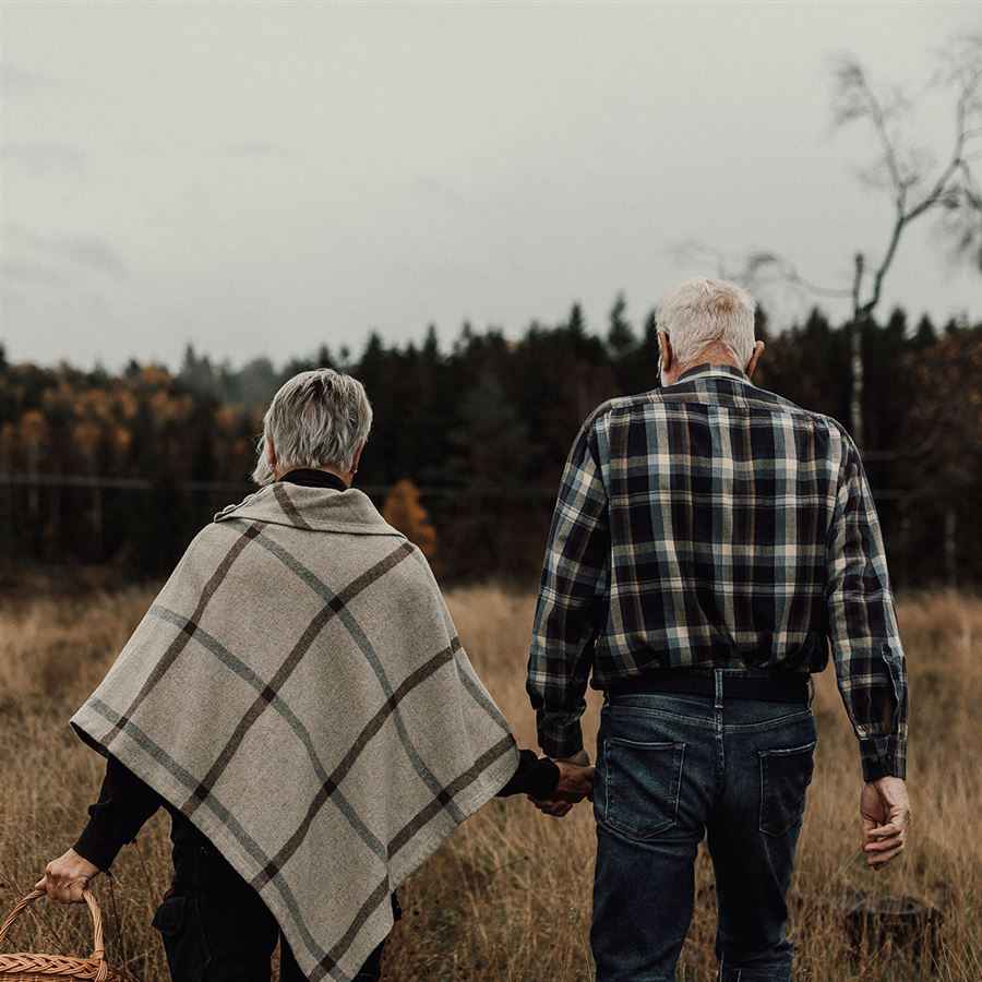 Ett äldre par promenerar i skogen