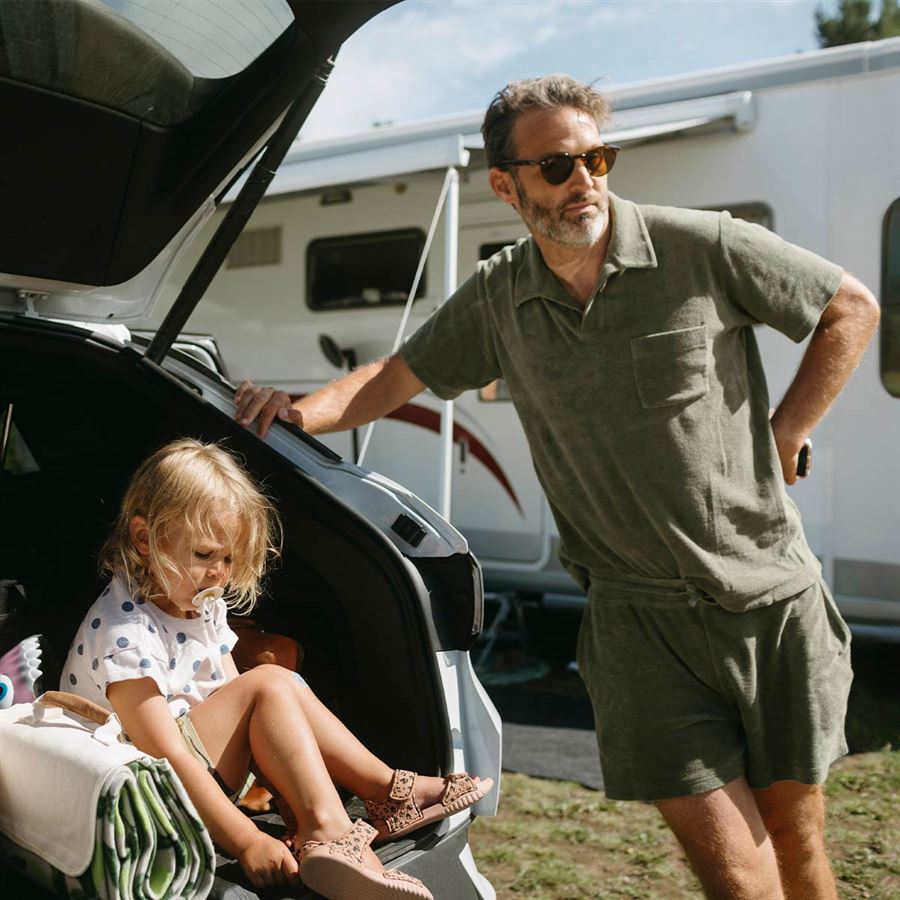 En pappa med sin dotter på en campingplats.
