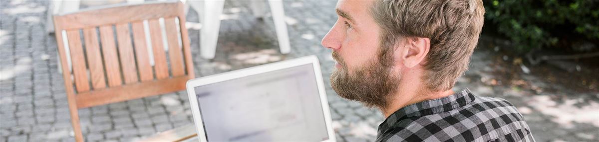 Man med laptop utomhus