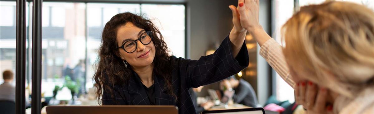 två kvinnor som gör slår ihop sina handflator i high five