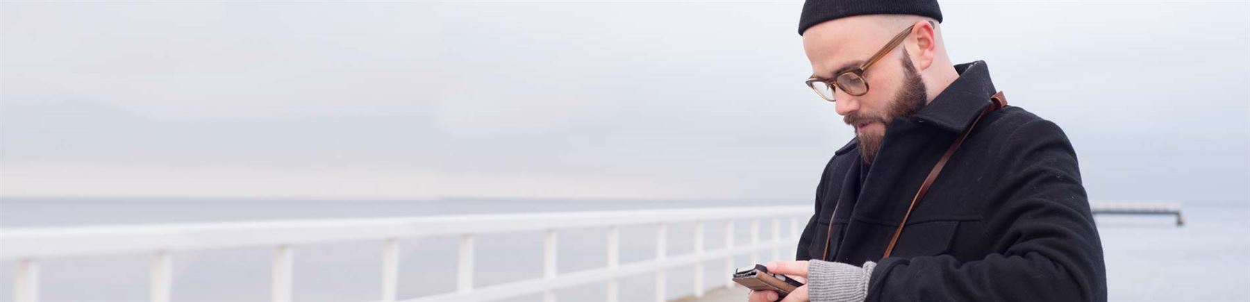 a man outside looking on his cellphone