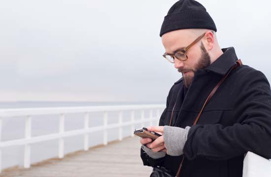 a man outside looking on his cellphone