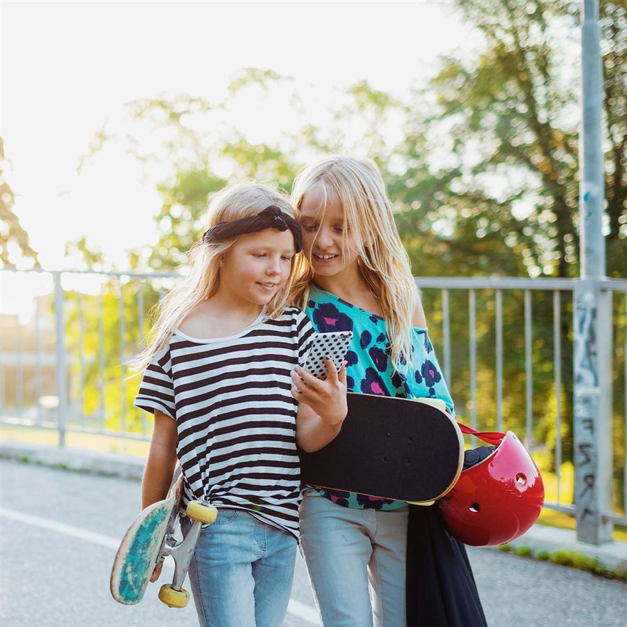 girls walking and watching mobile - Handelsbaken.se