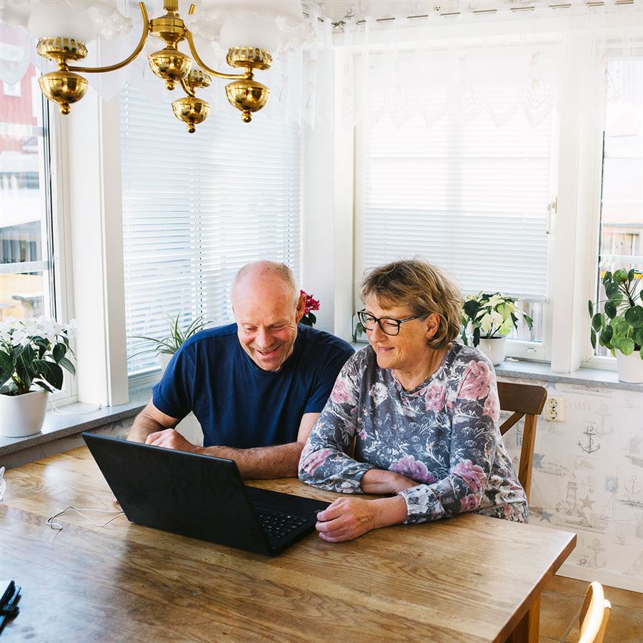 Ett äldre par vid datorn kollar sina trygghetsförsäkringar.