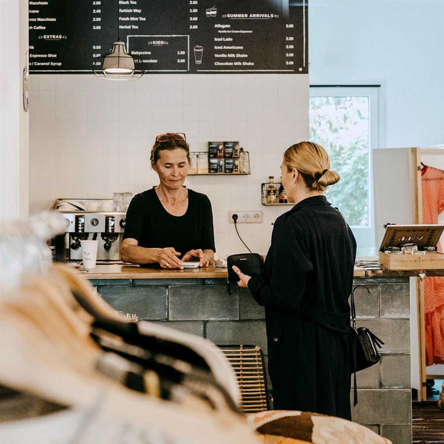 En kvinna betalar i kassan i en affär