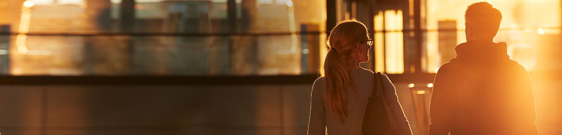 man and woman at train station with sunset  Handelsbaken.se