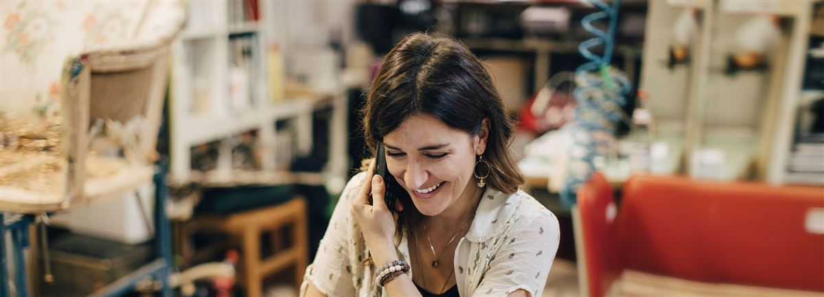 En kvinna pratar i telefon på sin arbetsplats