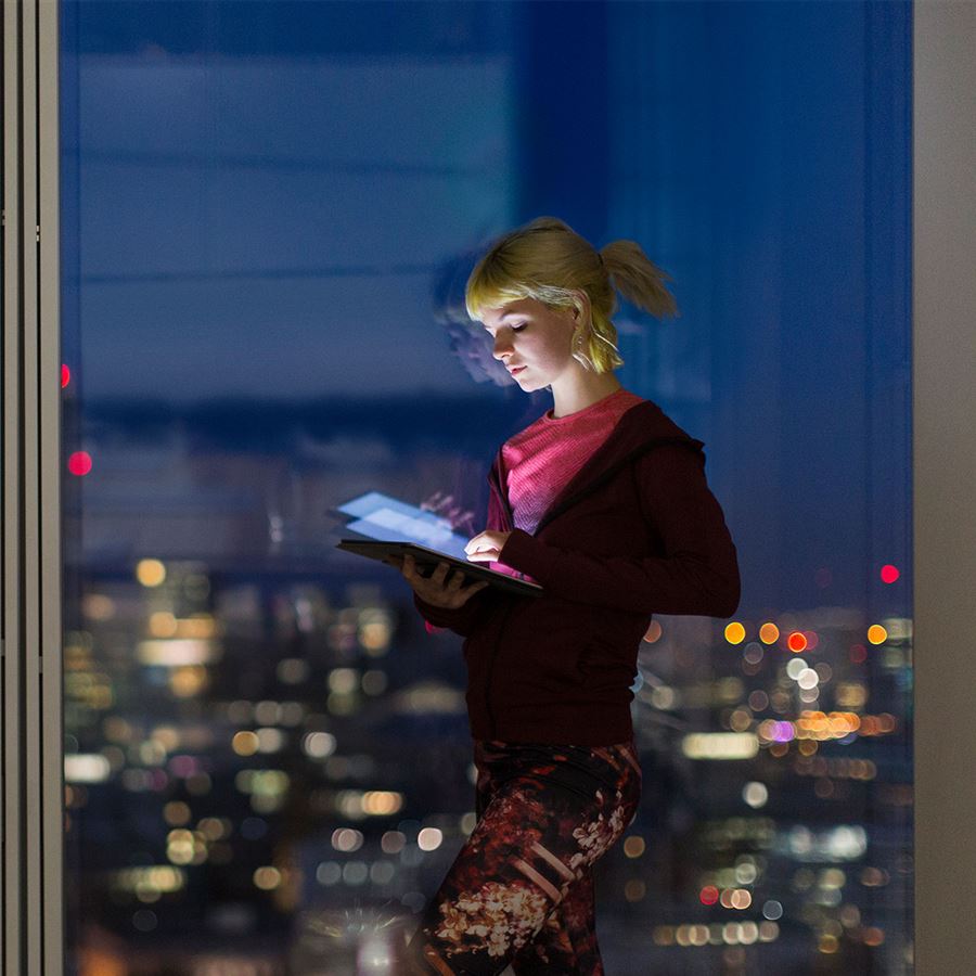 Kvinna tittar på sin iPad mitt i natten
