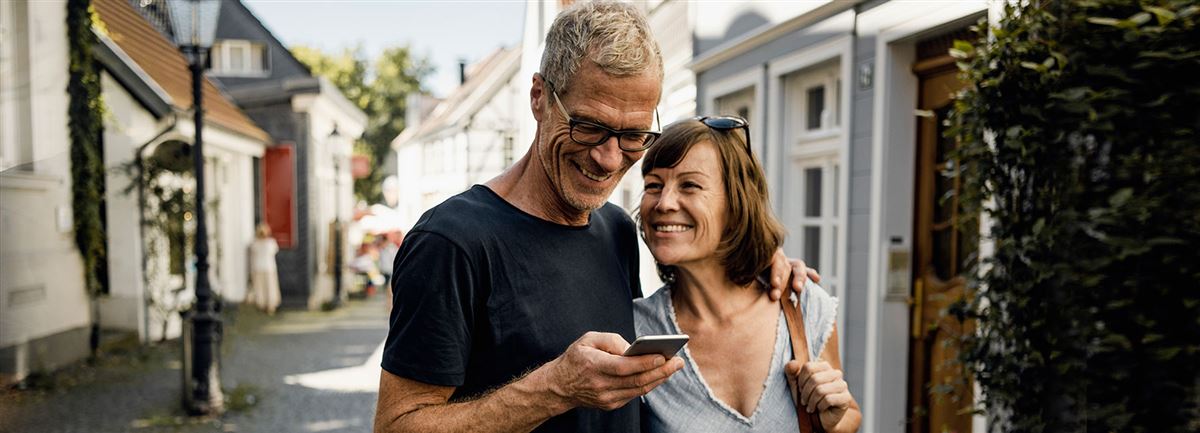 En man och en kvinna tittar i mobilen