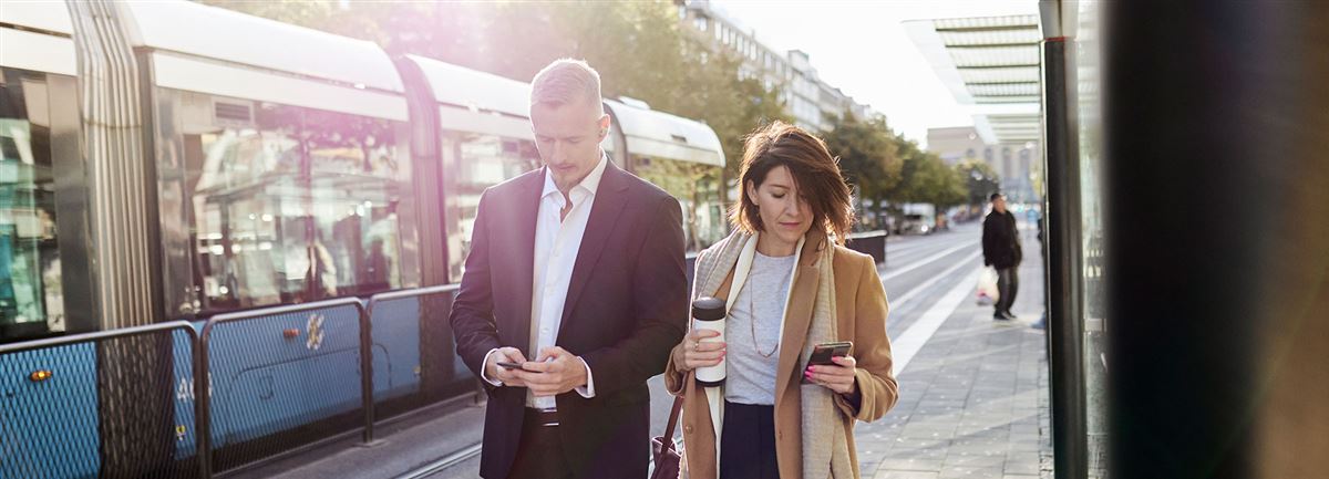 Man och kvinna på språng med företagsappen på mobilen