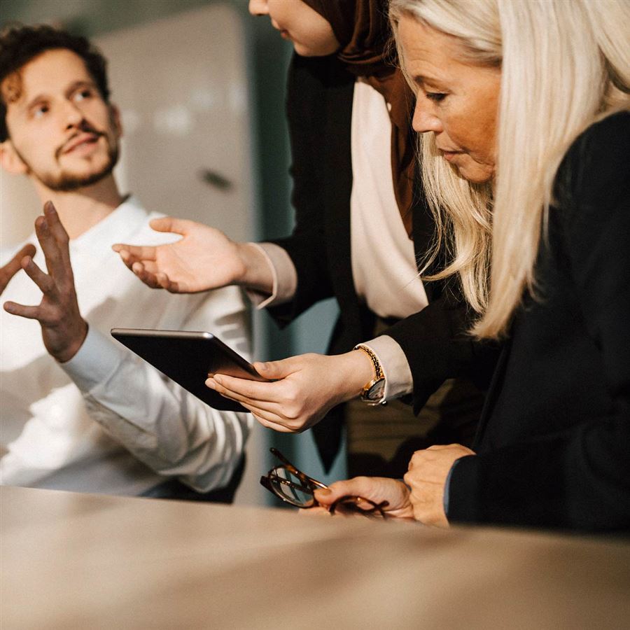 Tre kollegor diskuterar kapitalförvaltning.