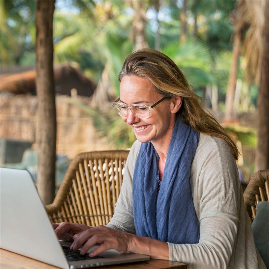 En kvinna sitter vid sin dator och planerar pensionen