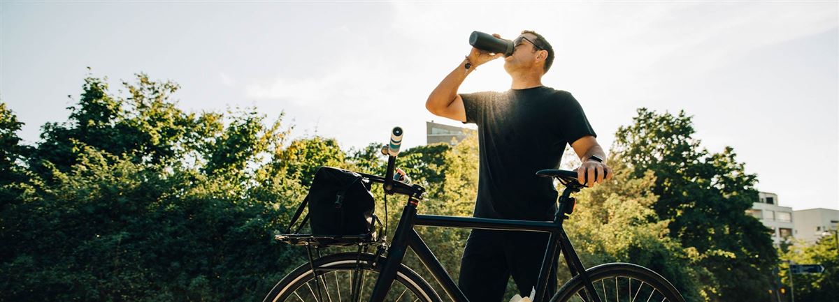 En cyklist tar en paus och dricker vatten