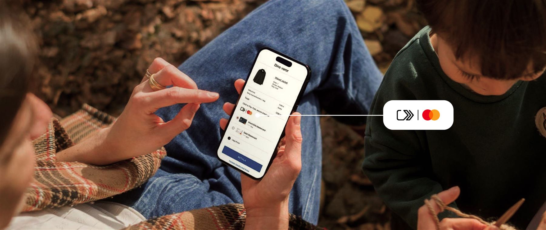 Närbild på kvinna med barn som använder click to pay på mobilen