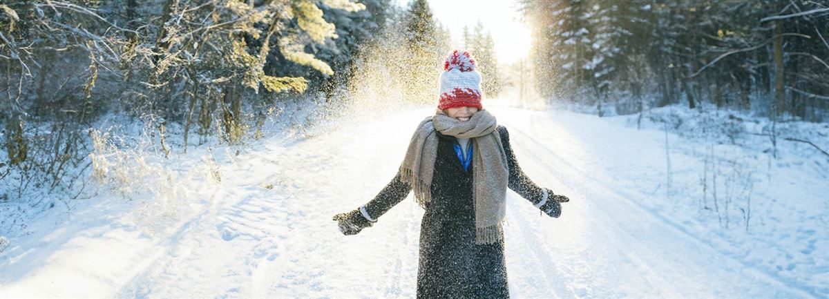 En glad kvinna utomhus en snöig dag. 