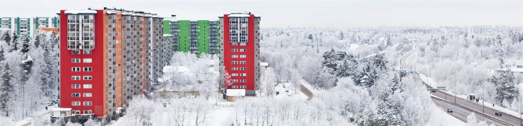 Bild på ett färgglatt bostadshus i ett vintrigt landskap.