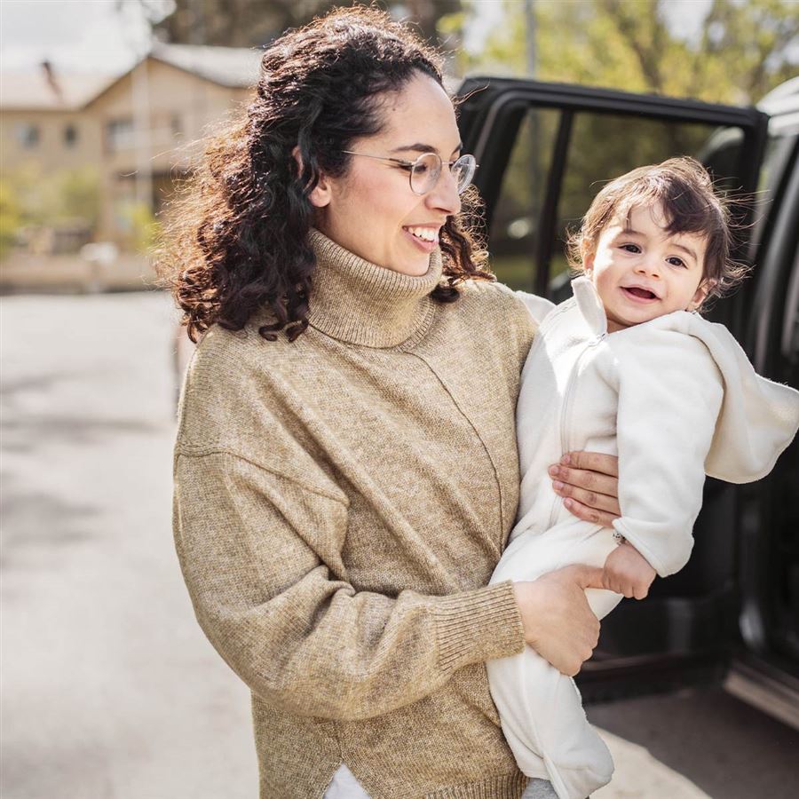 En mamma bär på sitt lilla barn. 