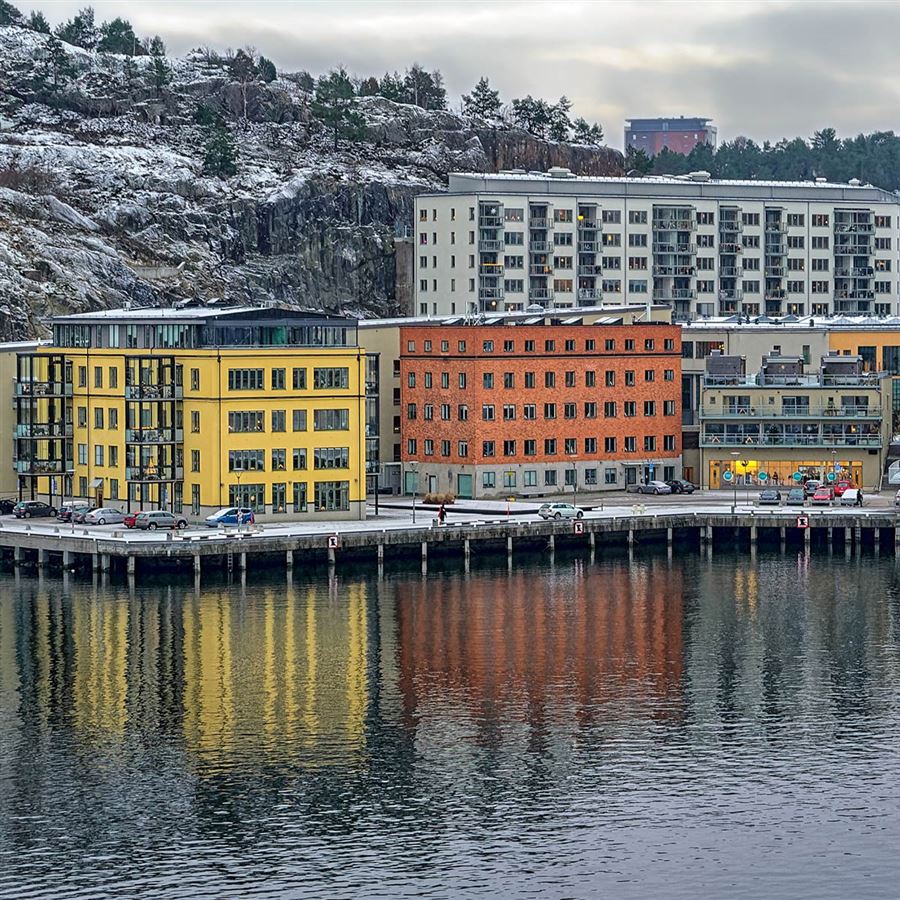 Färgglada flerfamiljshus vid en kaj.