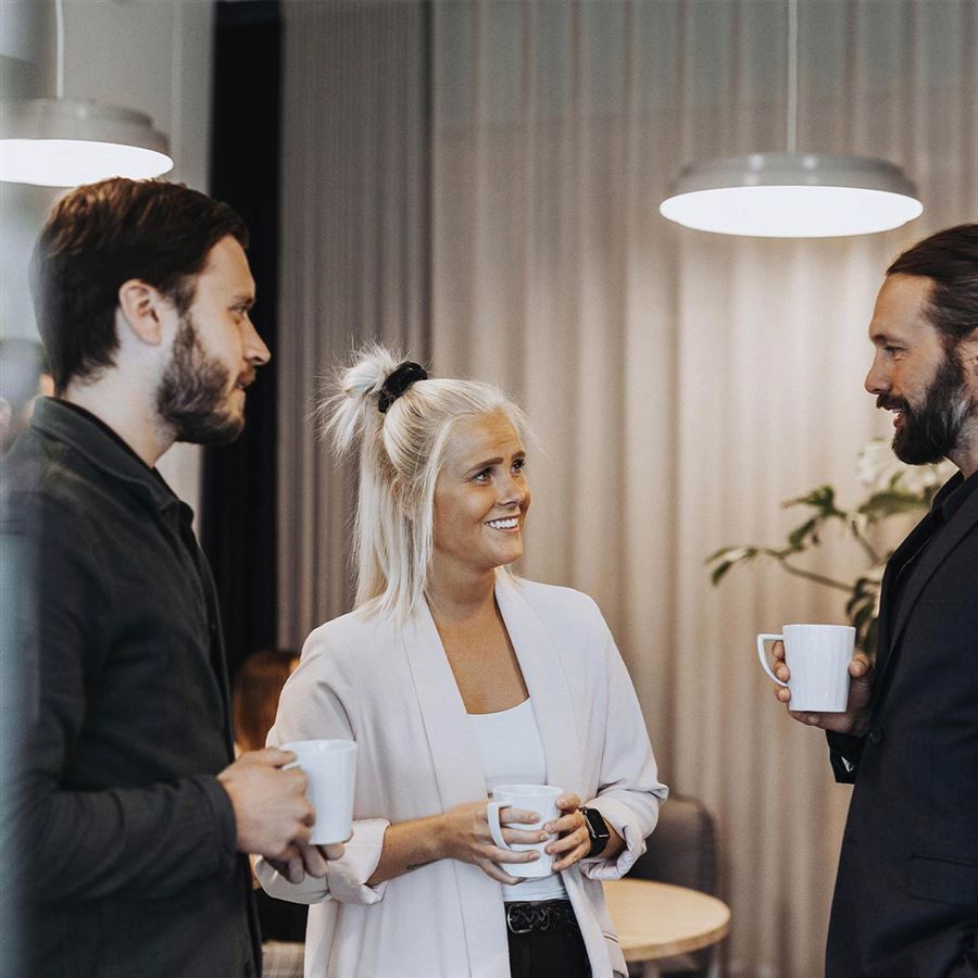 Kollegor som dricker kaffe tillsammans i ett kontorslandskap.