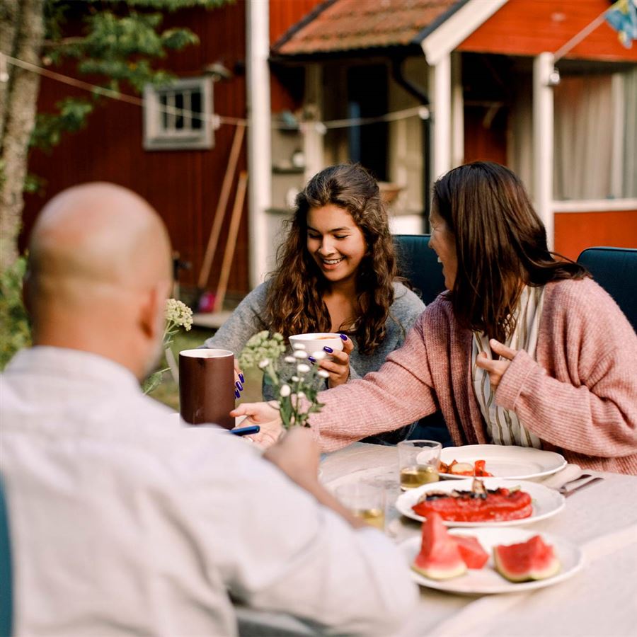 Familj fikar utanför sitt hus.