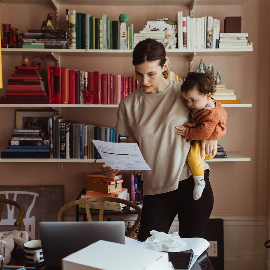 En mamma med sitt barn kollar på fakturor.