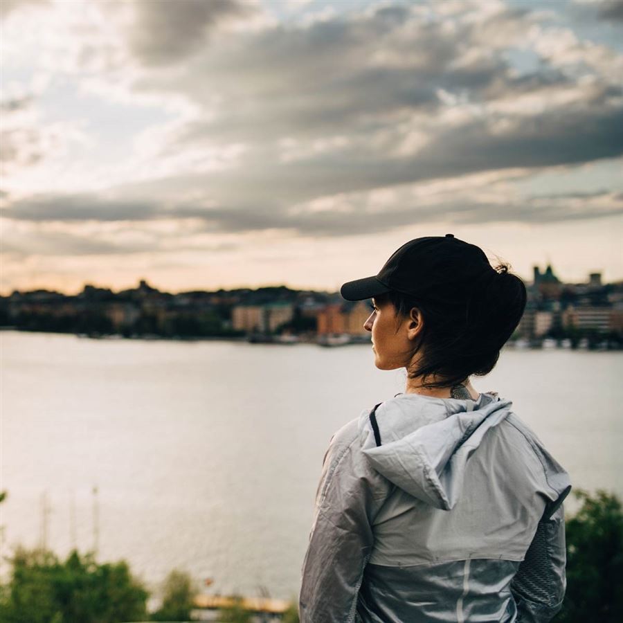 Kvinna i keps ser ut över Stockholm