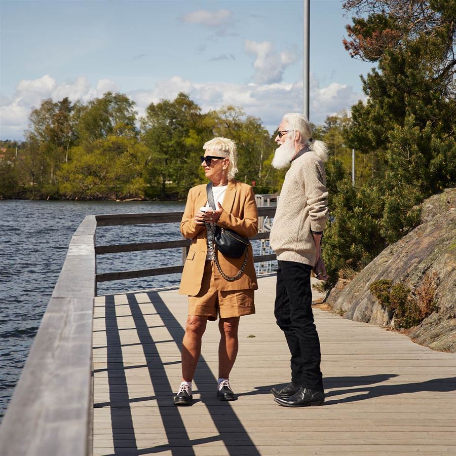 Ett äldre par står och blickar ut över en sjö.