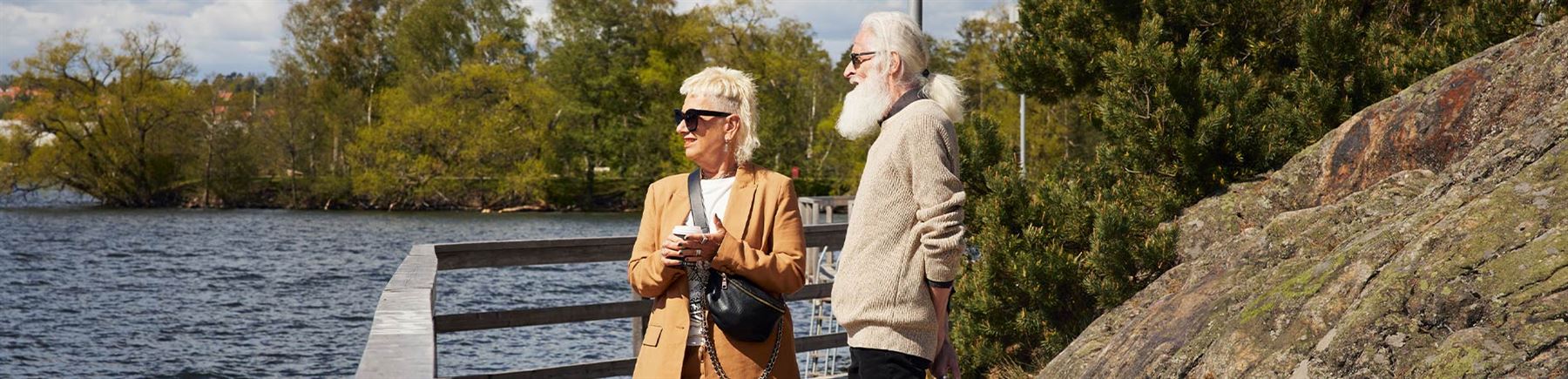 Ett äldre par som står och blickar ut över en sjö.