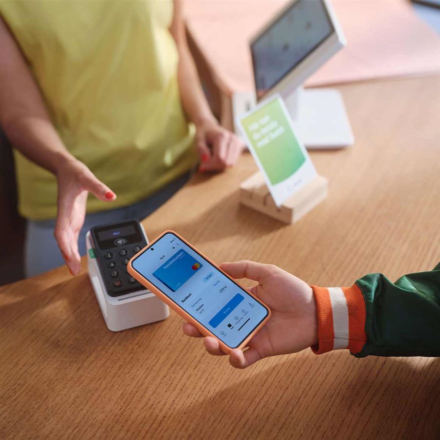 En person betalar med swish i butik.