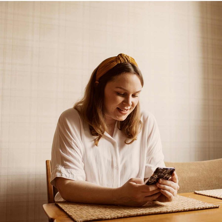 Kvinna läser boränteprognosen i sin mobil.