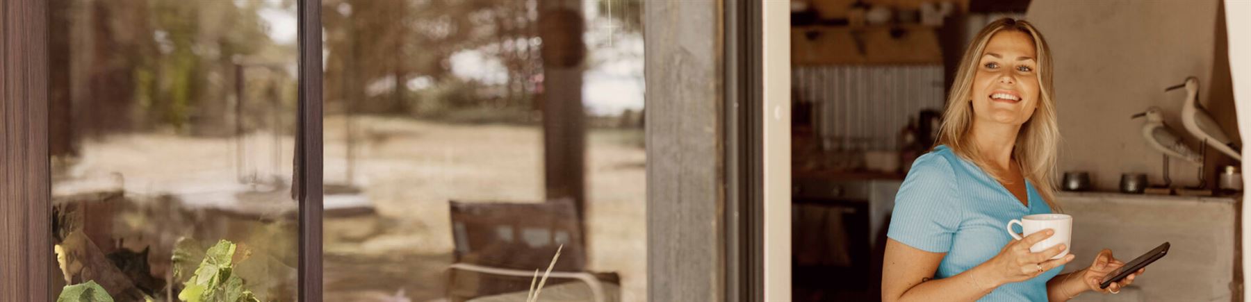 En leende kvinna med mobiltelefon. 