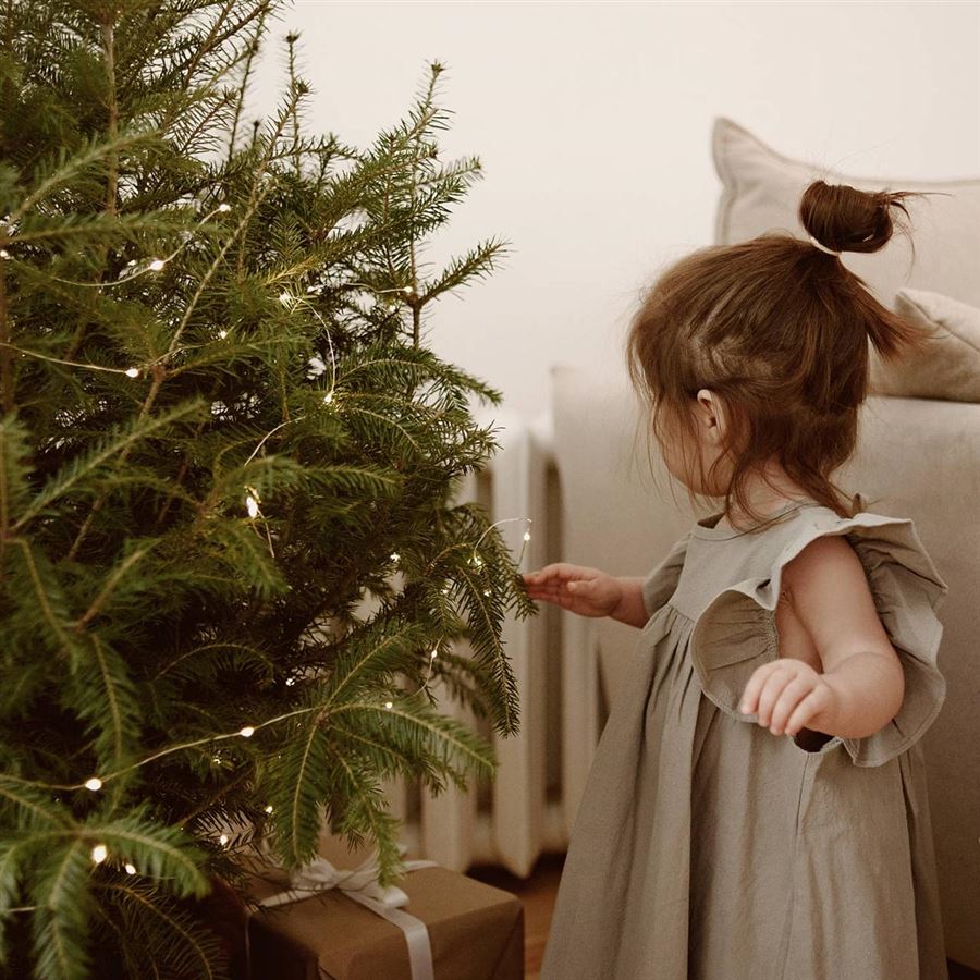 En flicka klär julgranen.
