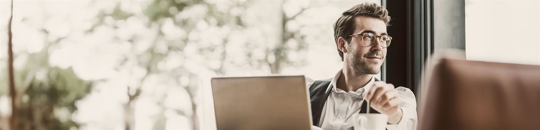 Man framför sin laptop som sätter upp sitt sparande.