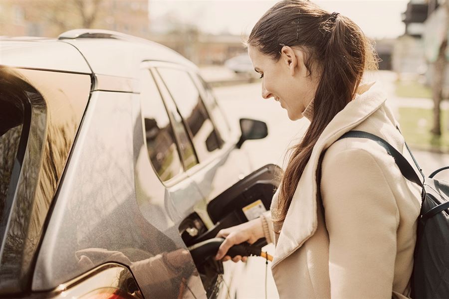 Kvinna laddar en elbil.