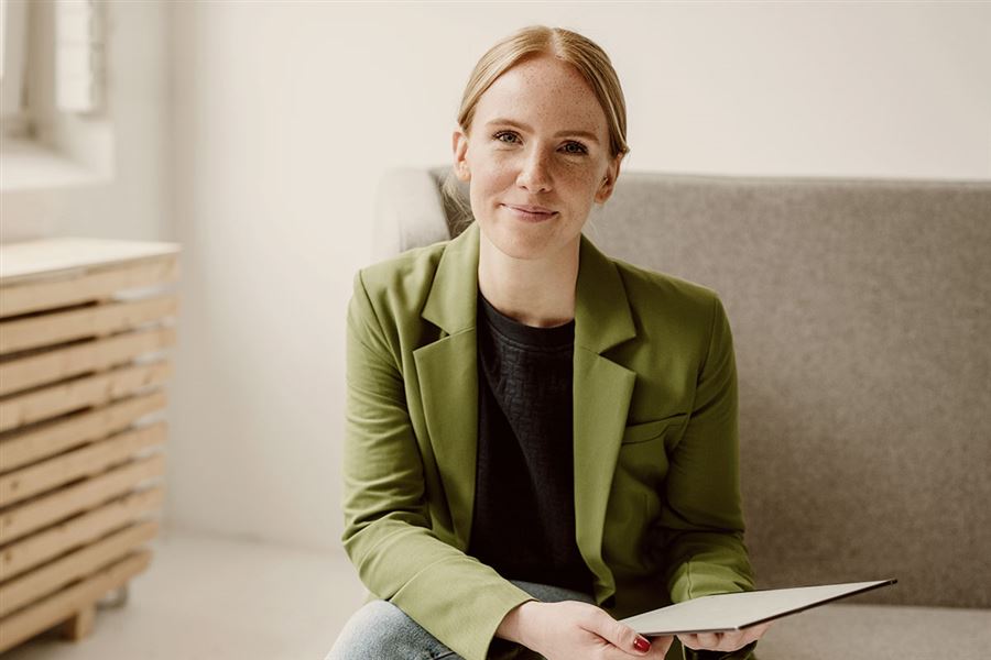 Leende affärskvinna i kontorsmiljö.