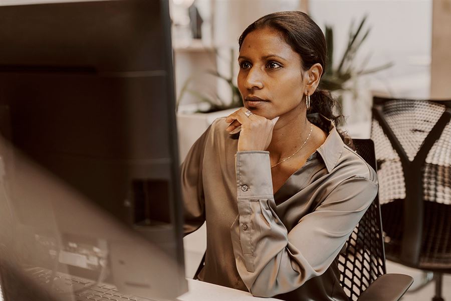 Kvinna sitter vid en datorskärm. 