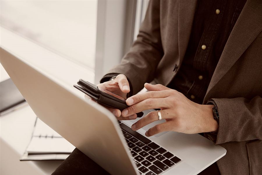 Händer som knappar på en laptop.