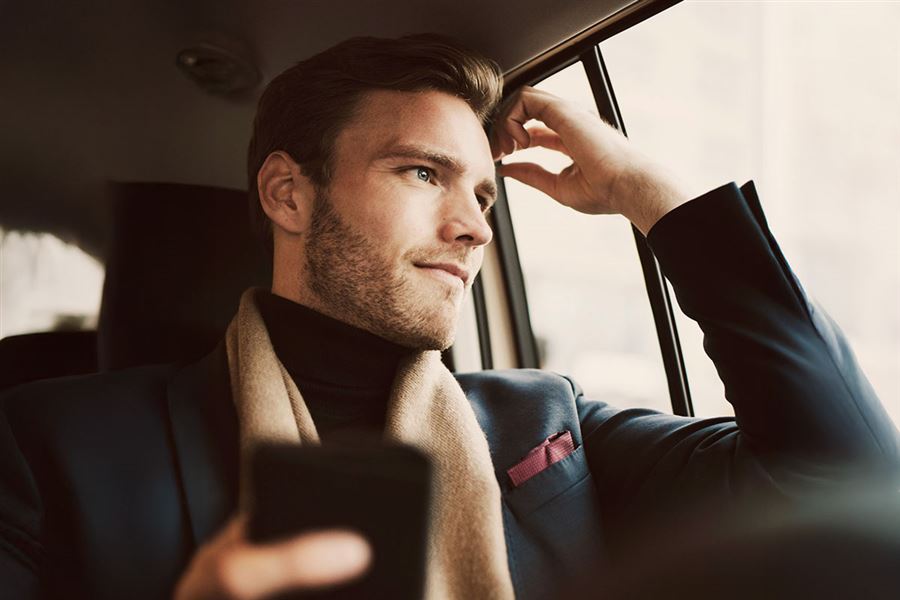 En affärsman sitter i baksätet på en taxi.