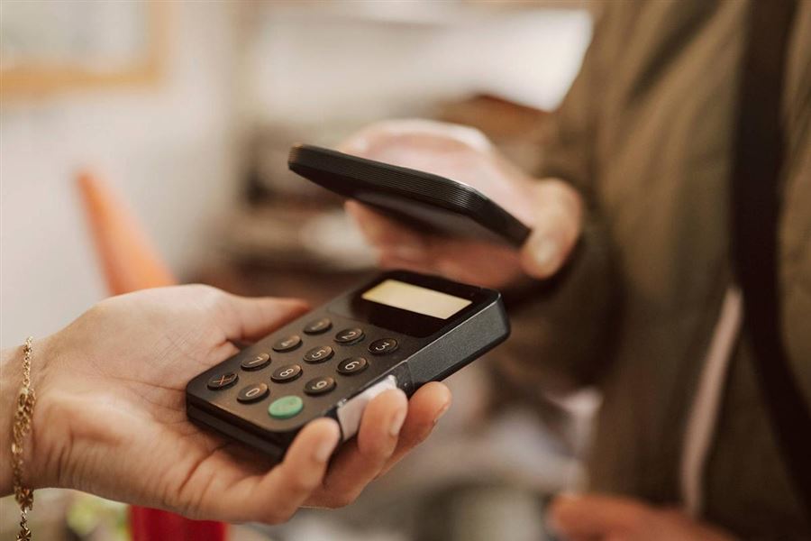 En person betalar med sin mobiltelefon i en terminal.