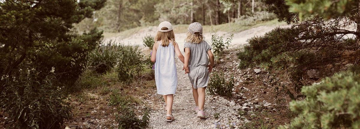 Två barn på promenad utomhus.