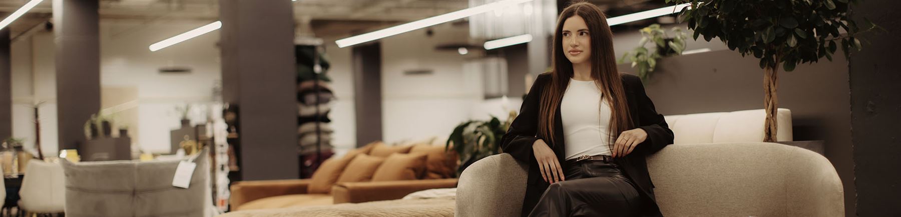 Kvinna som sitter i soffa i möbelaffär.