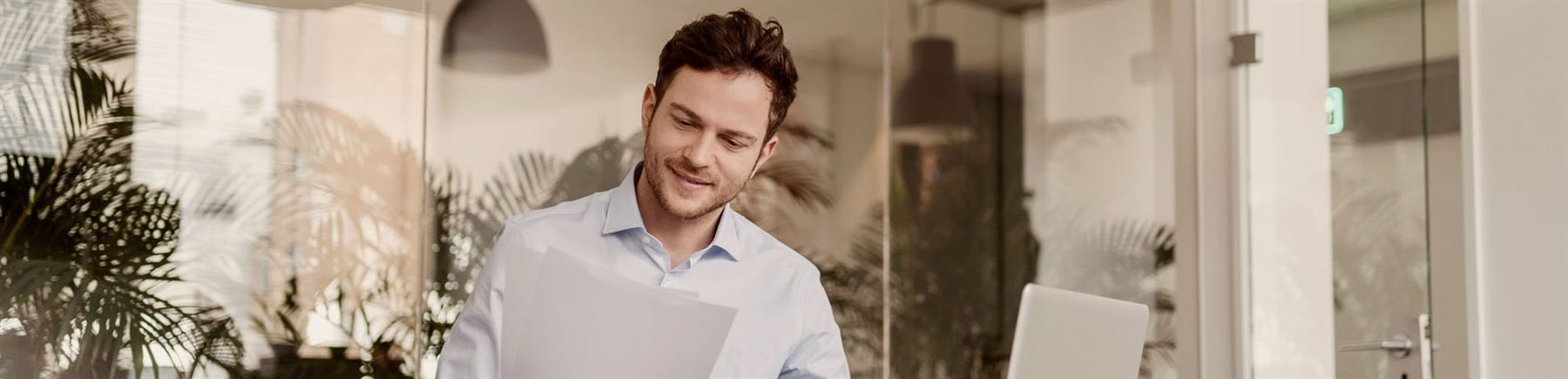 En egenföretagare sitter framför sin dator i en kontorsmiljö.