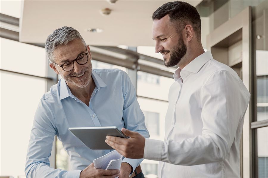 Två män tittar på en ipad.