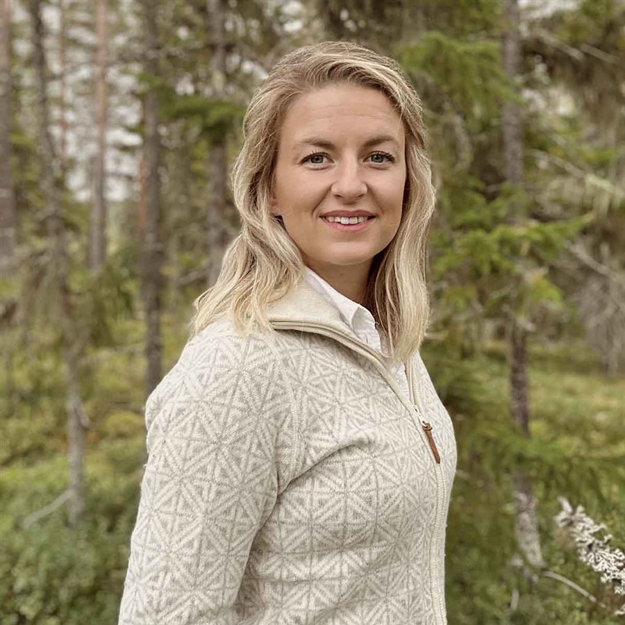 Linnea Åkerlund poserar i skogen. Linnea är länsansvarig för Skog och lantbruk, Handelsbanken i Västernorrland.