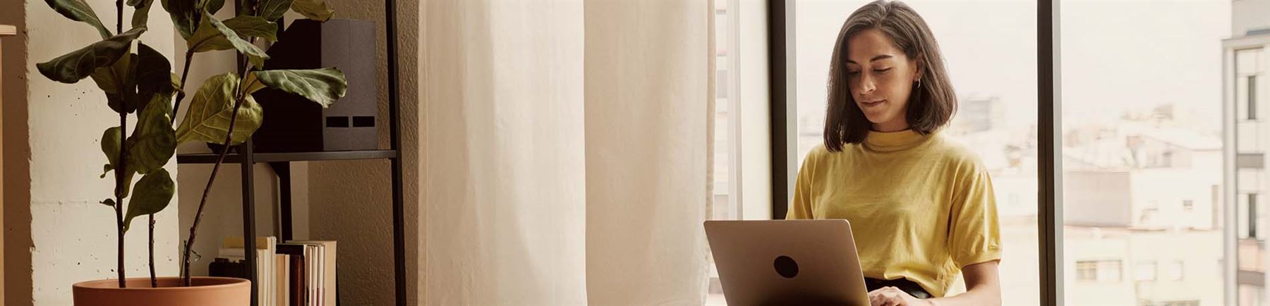 En kvinna med en laptop i knät.