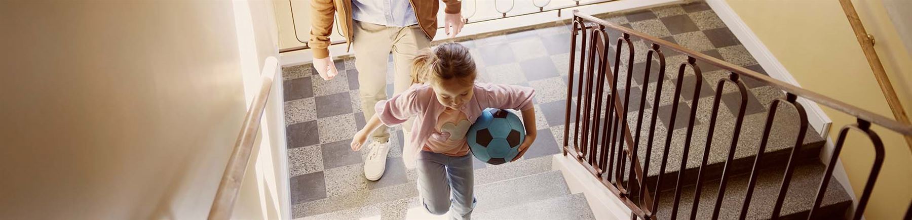 Pappa och barn i trappuppgång på väg till sin nya bostad.