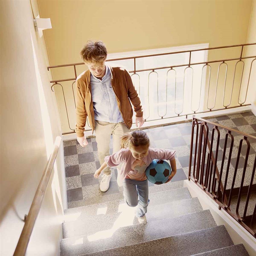 Pappa och barn i trappuppgång till sin nya bostad.
