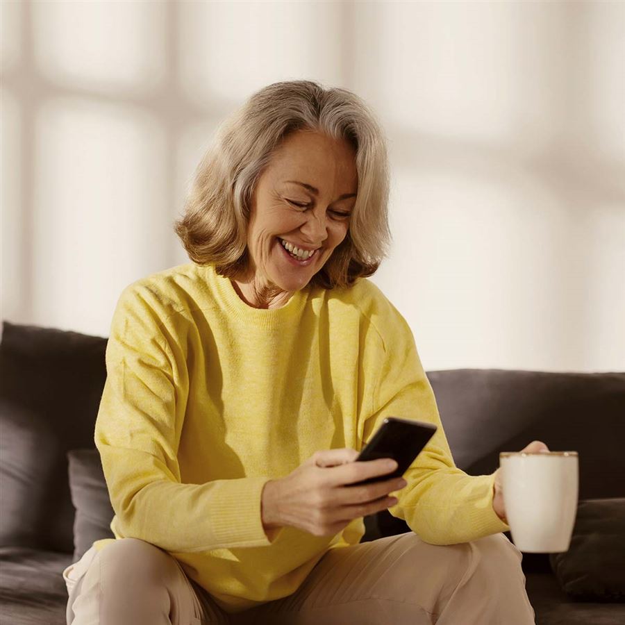 En kvinna tittar på sin mobiltelefon.