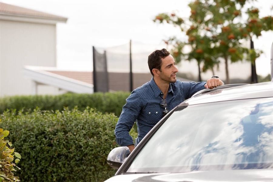 En man står bredvid en bil.