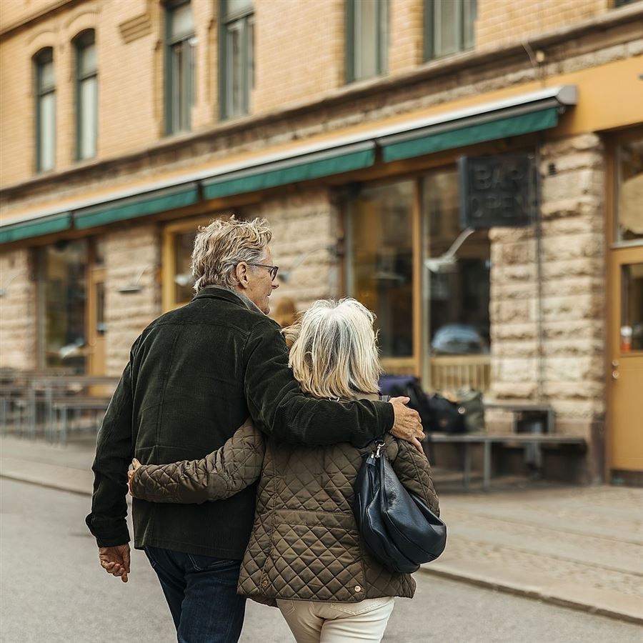 Äldre par som går igenom stad.